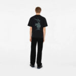 Maglietta nera oversize con grafica, pantaloni aderenti e stile casual moderno uomo vista dietro.