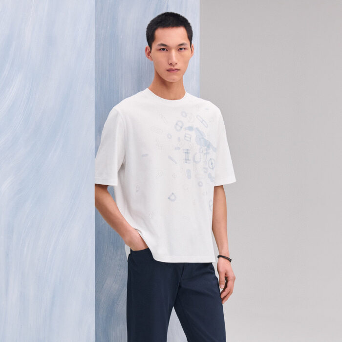 Uomo giovane in stile casual con T-shirt bianca e pantaloni navy, look moderno e rilassato.