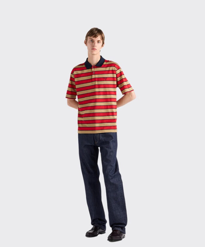 Uomo casual con polo a righe e jeans donker, look trendy e rilassato.