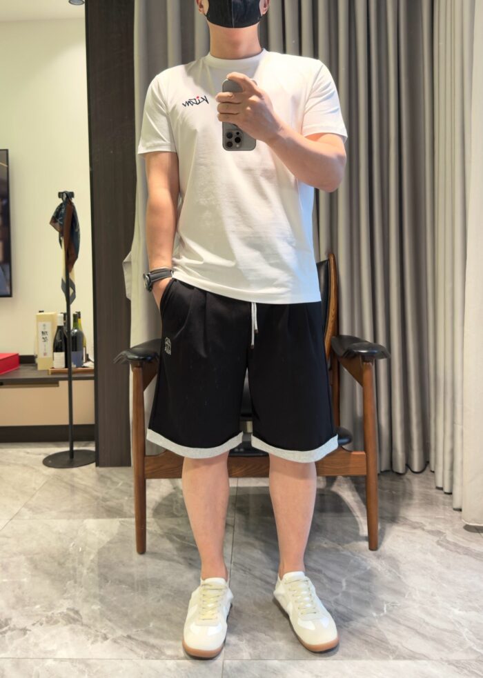 Uomo in abbigliamento casual con sneaker bianche, stile relax in casa o spazi informali.