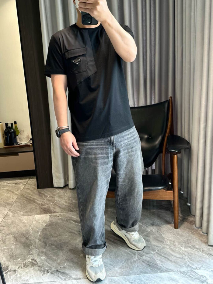 Uomo in jeans grigi e sneakers bianche, selfie nello specchio in ambiente elegante e rilassato.