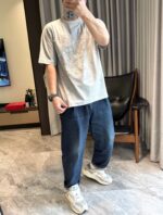 Uomo casual con jeans e sneakers bianche in un ambiente moderno e luminoso.