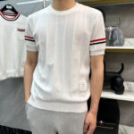 Uomo moderno in relax e stile casual con maglietta a righe e jogger grigi.