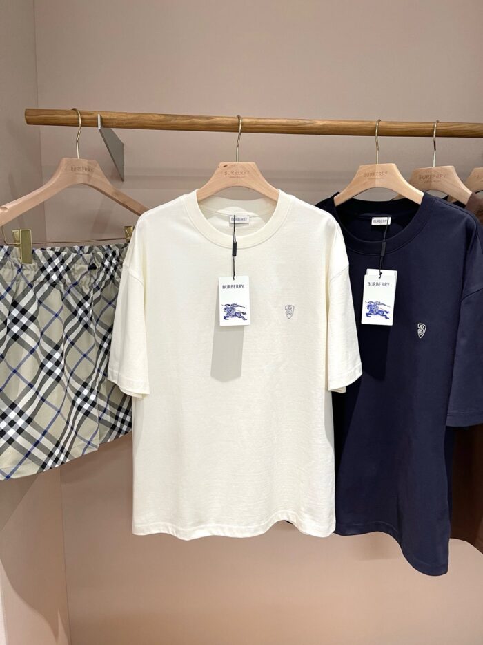 Set di abbigliamento casual minimalista con t-shirt crema, navy e gonna a quadri neutra.