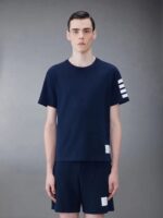 Abbigliamento sportivo navy uomo, t-shirt con righe e shorts coordinati, look casual e moderno.