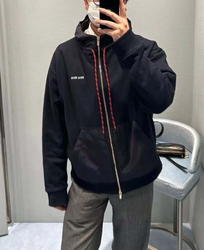 Selfie di stile urbano con felpa nera, pantaloni grigi e mascherina moderna.