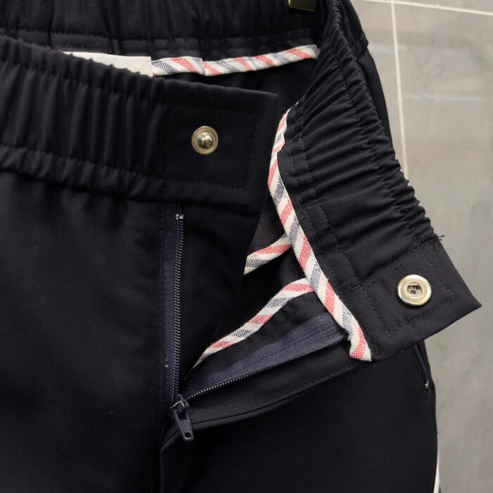 Pantaloni navy con elastico, zip e fodera a righe per stile e comfort raffinato.