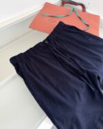 Pantaloncini navy casual con borsa arancione per look estivo e comfort.