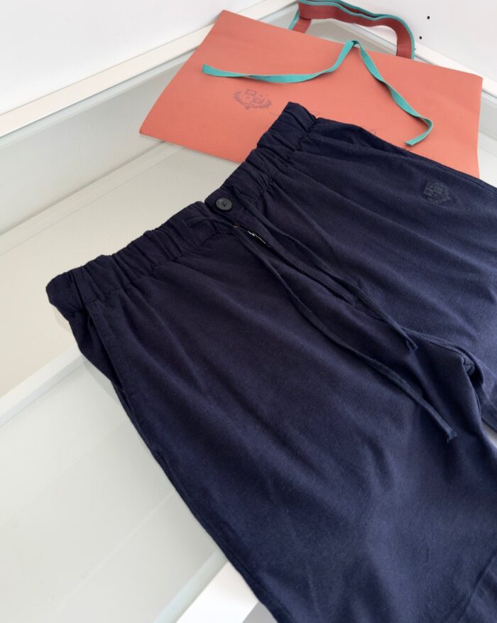 Pantaloncini navy casual con borsa arancione per look estivo e comfort.
