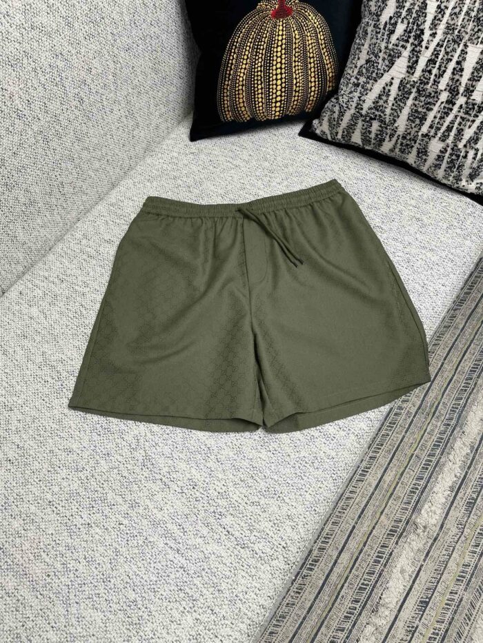 Pantaloncini casual verde oliva su divano con cuscini decorativi e atmosfera rilassante.