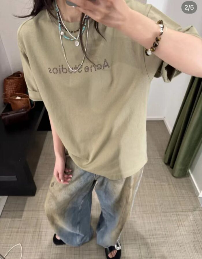 Look casual con T-shirt verde oliva, jeans oversize e accessori trendy.