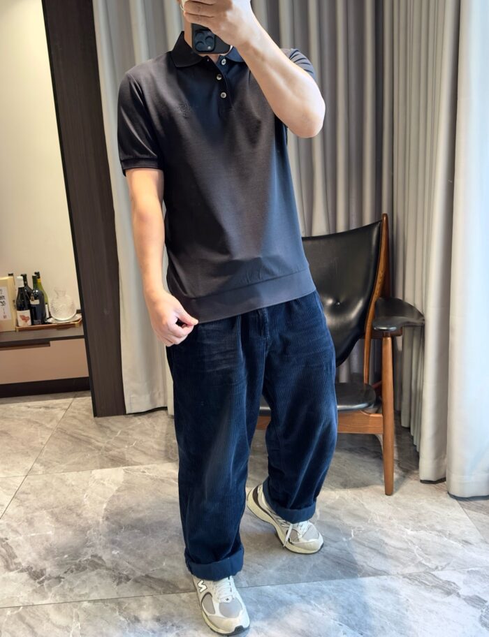 Elegante outfit casual con polo, jeans oversize e sneakers in un ambiente moderno e raffinato.