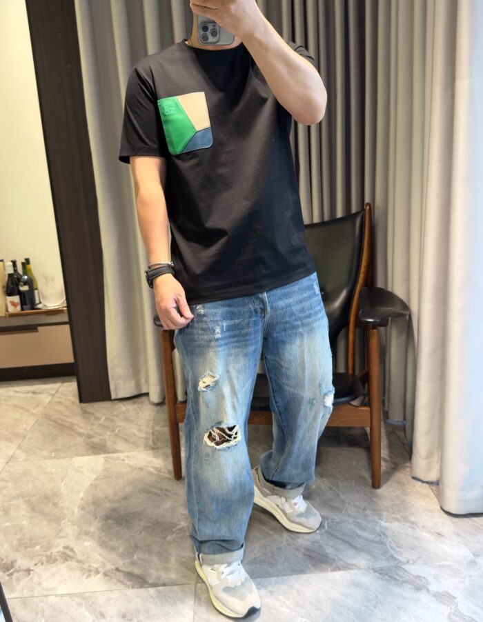 Look casual chic con jeans distressed, t-shirt color block e sneakers chunky moderne.