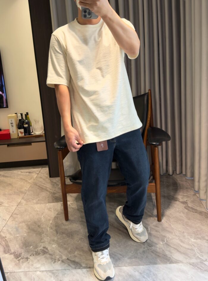 Outfit casual con jeans, sneakers e ambiente moderno e accogliente.