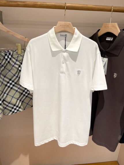 Abbigliamento estivo: polo bianca, shorts a quadri e polo marrone in negozio.