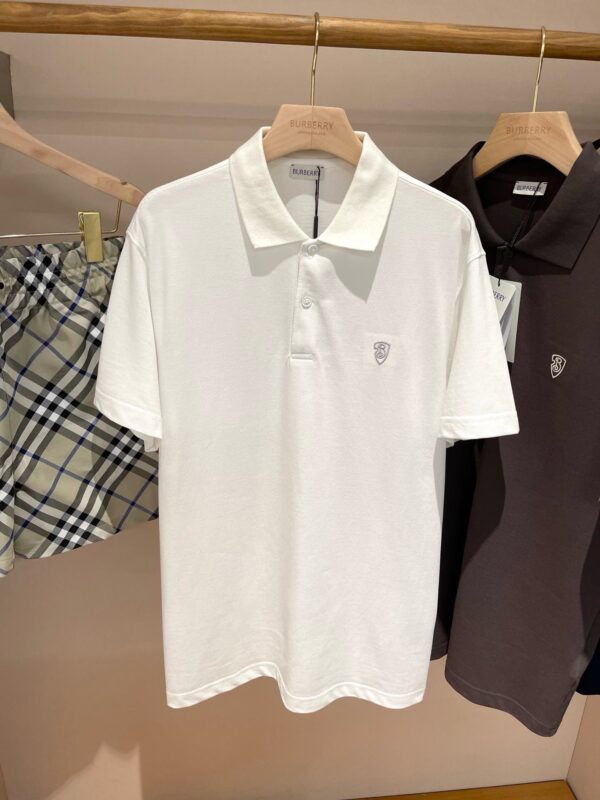 Abbigliamento estivo: polo bianca, shorts a quadri e polo marrone in negozio.