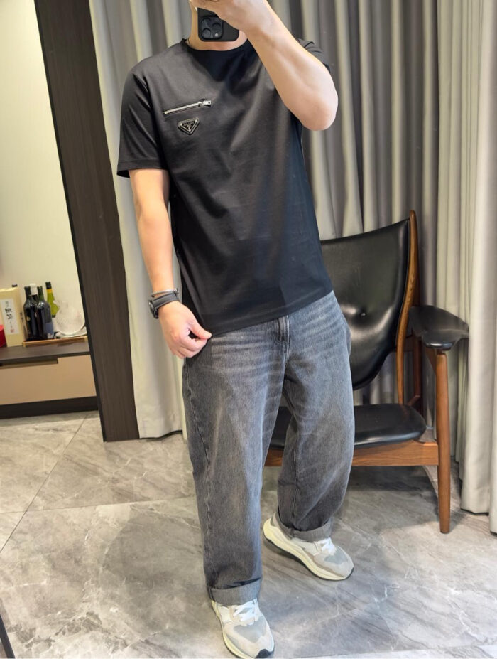 Selfie in stile casual con jeans chiari, t-shirt nero e sneakers bianchi moderni.