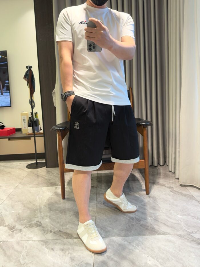 Donna in outfit casual sportivo mentre scatta un selfie in soggiorno moderno.