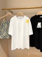 Abbigliamento casual: T-shirt bianca, gonna check e top nero su asta in legno.
