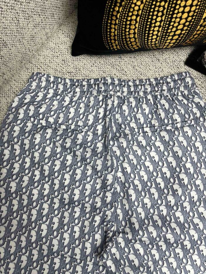 Pantaloni casual con motivo astratto blu e bianco, vita elastica e tasche posteriori.