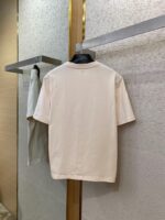 Maglietta casual pastello su supporto elegante in ambiente moderno e sofisticato.