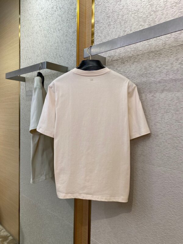 Maglietta casual pastello su supporto elegante in ambiente moderno e sofisticato.