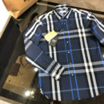Camicia uomo a quadri navy, collo spagliato, stile casual eleganti su superficie lucida.