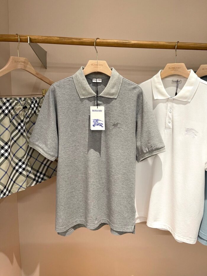 Vetrina con polo casual grigia e bianca, sfondo a quadri e stile elegante e versatile.