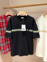 Esposizione di magliette casual trendy: nero, rosso a quadri e bianco con dettagli colorati.