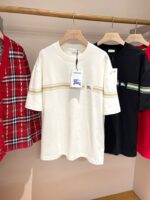 Vetrina di T-shirt casual colorate con righe, plaid e design minimalista in negozio.