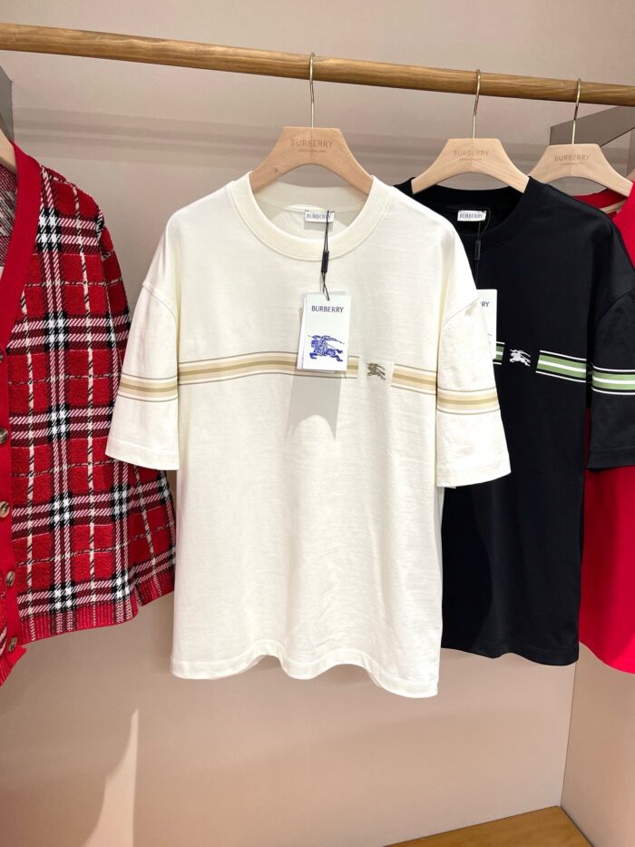 Vetrina di T-shirt casual colorate con righe, plaid e design minimalista in negozio.