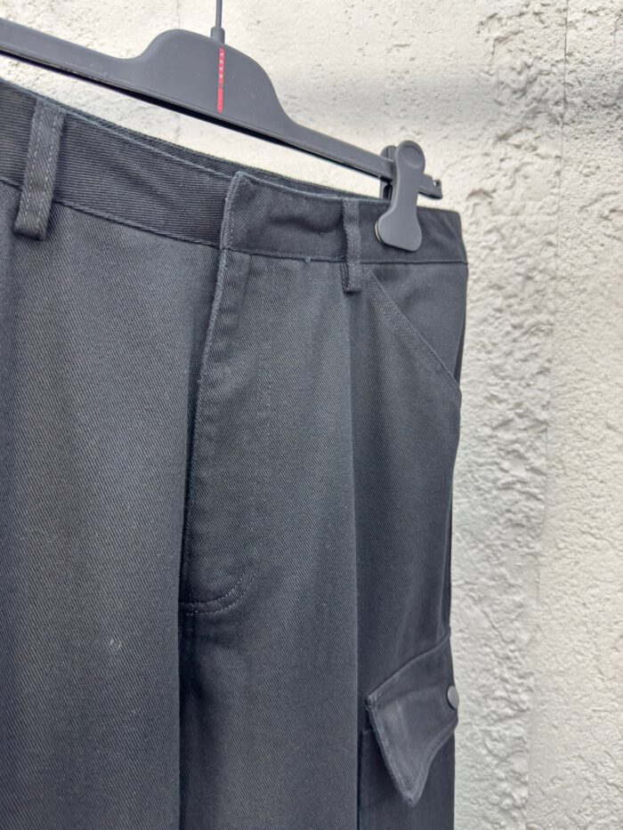 Pantaloni neri cargo eleganti con tasca laterale, ideali per uno stile casual e moderno.