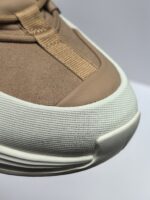 Sneaker beige in suede con suola bianca e inserti elasticizzati, stile casual e moderno.
