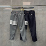 Pantaloni sportivi grigi con strisce e navy minimalisti, perfetti per uno stile casual e moderno.