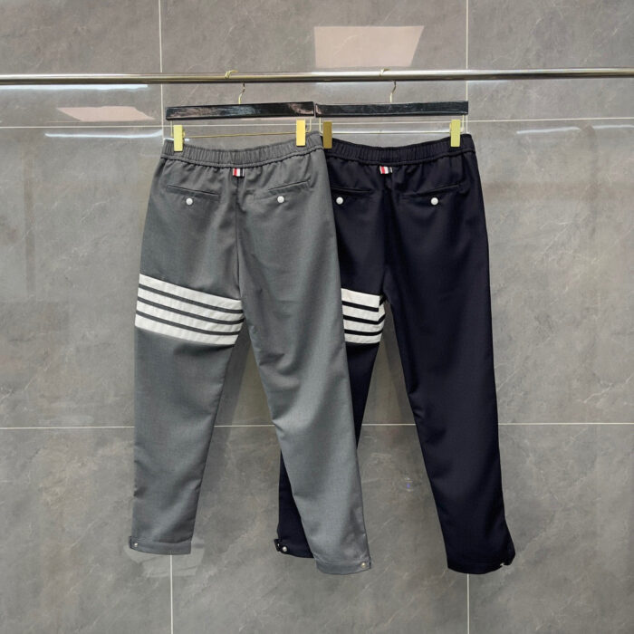 Pantaloni sportivi grigi con strisce e navy minimalisti, perfetti per uno stile casual e moderno.