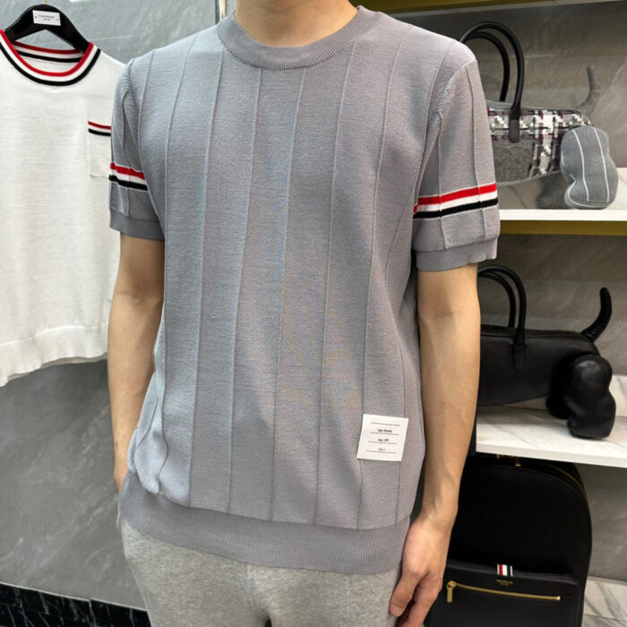 Maglione grigio sportivo con dettagli a righe e stile casual elegante.