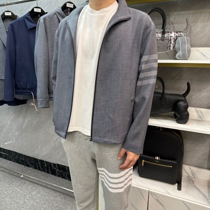 Outfit casual sportivo uomo con giacca grigia, t-shirt bianca e pantaloni jogger grigi.