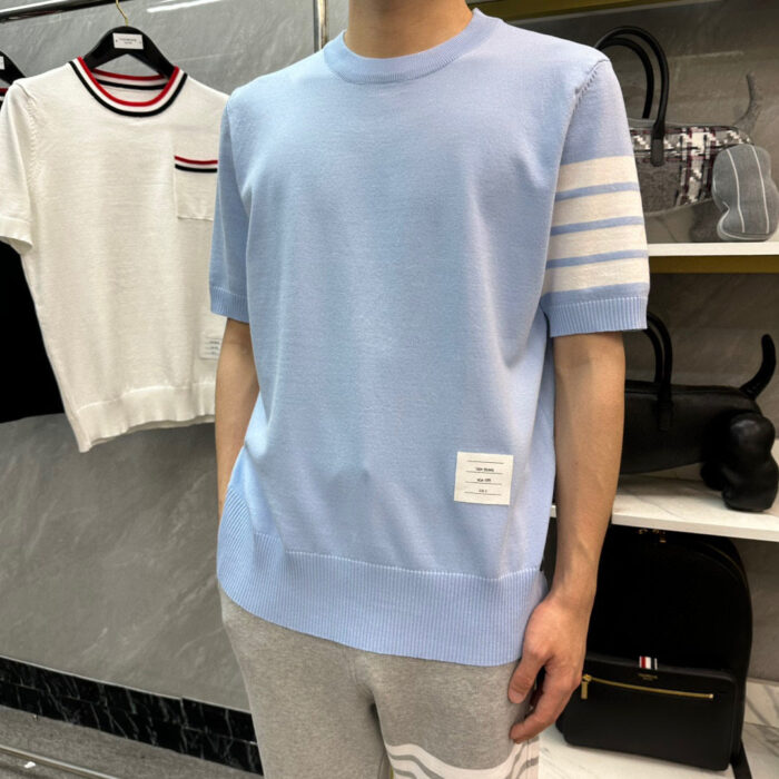 Vestito casual sportivo con t-shirt blu con strisce e pantaloni grigi, stile moderno e confortevole.