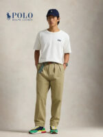 Uomo in stile casual con sneakers colorate, cappellino navy e pantaloni khaki, look moderno e rilassato.