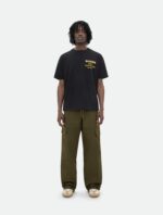 Look street casual con t-shirt nera, cargo verde oliva e sneakers beige.
