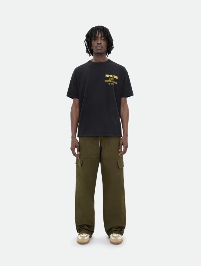 Look street casual con t-shirt nera, cargo verde oliva e sneakers beige.