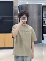 Ragazzo in negozio fa selfie con abbigliamento casual e stile moderno.