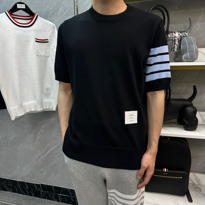 Uomo con T-shirt sportiva nera e joggers grigi in negozio dabbigliamento moderno.