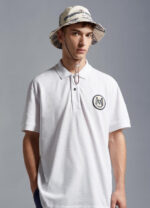 Stile casual con polo bianca e cappello bucket, perfetto per look giovane e alla moda.