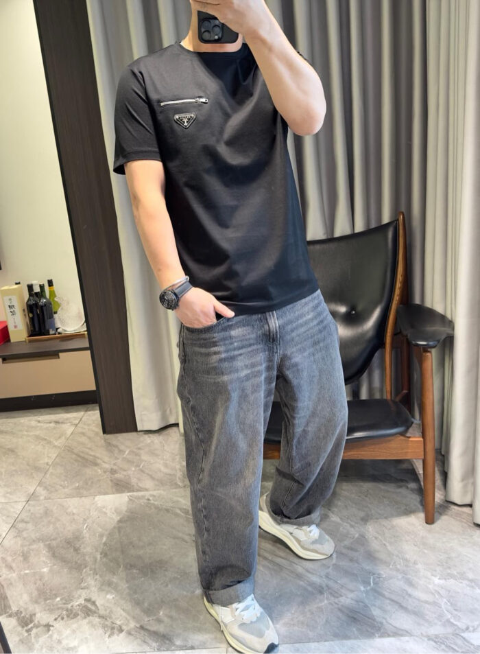 Persona in abbigliamento casual moderno che si scatta un selfie davanti a uno sfondo elegante.