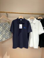 Set estivo con polo, shorts a quadretti e gonna a righe su scaffale di legno.