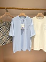 Outfit estivo casual con T-shirt blu ricamata e shorts a quadri leggeri.