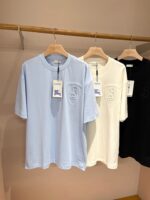 Magliette casual in blu, bianco e nero su supporto in legno, stile semplice e versatile.