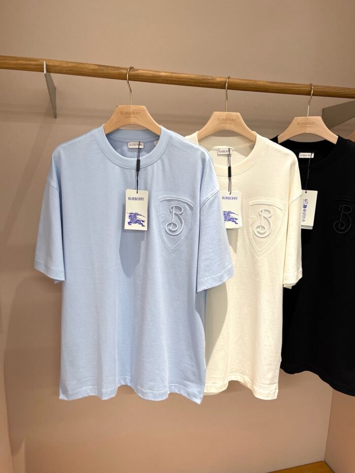 Magliette casual in blu, bianco e nero su supporto in legno, stile semplice e versatile.