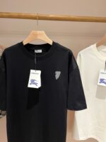 T-shirt nere e bianche casual su bastone in legno, stile semplice e raffinato.